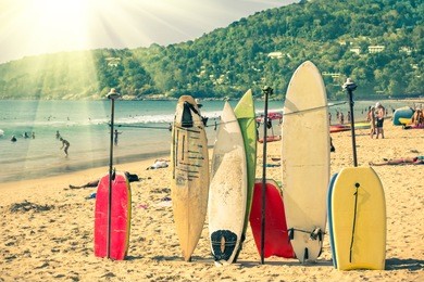 multicolored surfboards at  kata beach in phuket island - surf boards at tropical exclusive destination in south east asia - wonders of thailand on vintage filtered look with enhanced sunshine