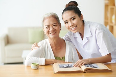 young nurse taking care of aged female in clinic