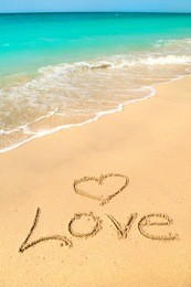 love sign on the beach with turquoise water