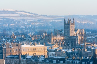 winter scenic showing bath abbey surrounded by georgian architecture and countryside in bath, england, uk.