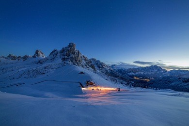 night view on passo ghiau and cima ra gusela and lights of car, dolomites - italy