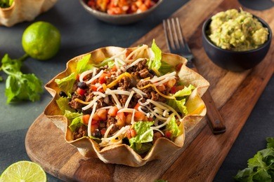 taco salad in a tortilla bowl with beef cheese and lettuce