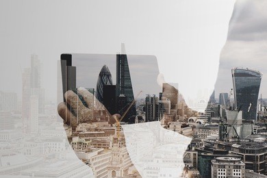 double exposure of success businessman using digital tablet with london building and social media diagram