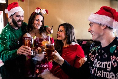 festive friends drinking beer and cocktail in bar