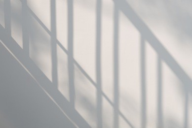 shadow of steel fence on the white wall in the one day afternoon.