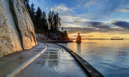 seawall and rock wall at sunset, with famous siwash rock in the sea water, stanley park, vancouver, british columbia, canada