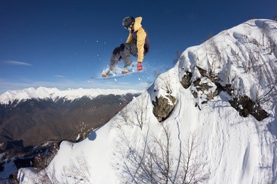 flying snowboarder on mountains. extreme sport.