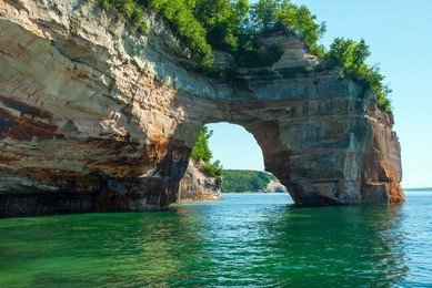 arch of rock extends from the shoreline directly in lake superior, pictured rocks national lakeshore, michigan