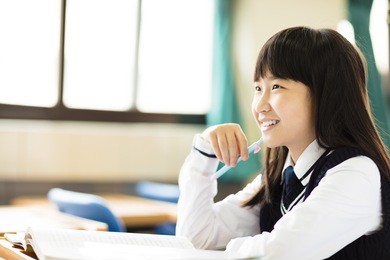 happy pretty  student girl with books in classroom