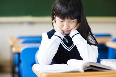 stressed student of high school sitting in classroom