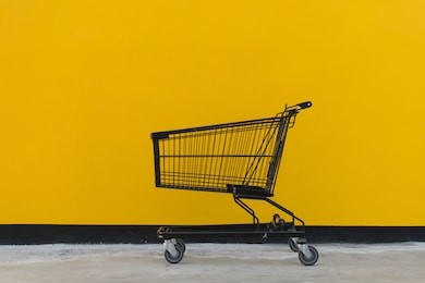 minimalism style, shopping cart black color and yellow wall at supermarket.