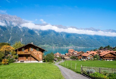 scenery of wood chalets  over swiss alps on lake brienz, interlaken.