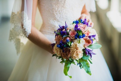 bride holding a wedding bouquet with blue flowers
