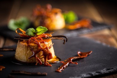 vanilla flan dessert served on black slate