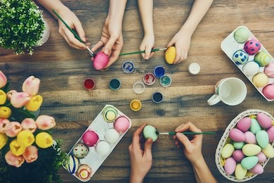 happy easter! a mother, father and their daughter painting easter eggs. happy family preparing for easter. 