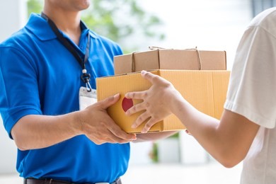 woman hand accepting a delivery of boxes from deliveryman