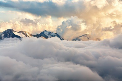 scenic alpine landscape with peaks covered by snow and clouds. natural mountain background