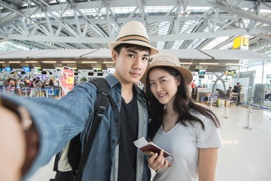 asian couple tourist taking a selfie in airport before journey 