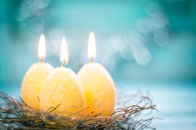 easter concept with candle eggs on wooden background.soft focus