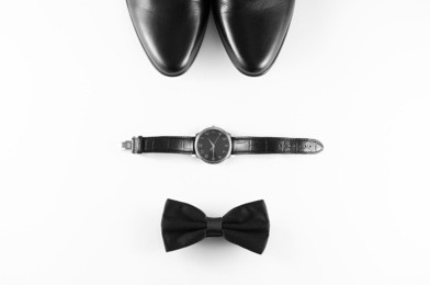 men's accessories: men's shoes, watch, bow tie.black and white minimalistic composition on a white background. classic men's accessories. top view