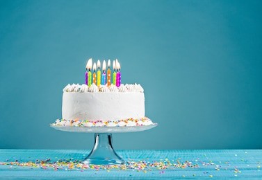 white birthday cake over blue background