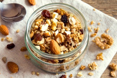 homemade granola with nuts and seeds in glass jar for healthy breakfast