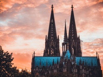 cologne dome with orange background and tree on the left side