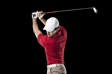 golf player in a red shirt taking a swing, on a black background.