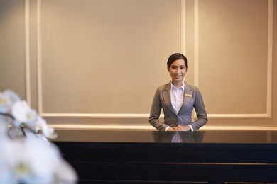 pretty young vietnamese girl standing at hotel reception