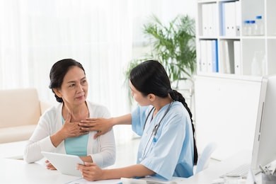 young doctor talking to senior patient about heart diseases