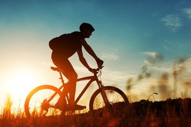 rider on mountain bicycle it the field