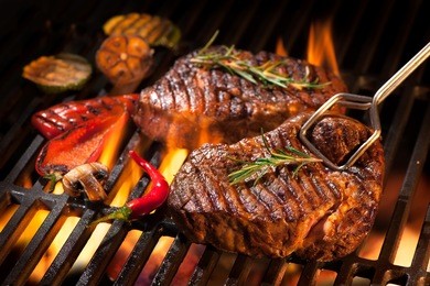 beef steaks on the grill with flames