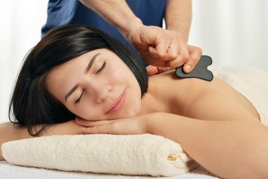 woman receiving gua sha acupuncture treatment on back