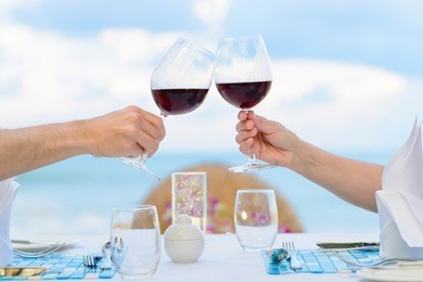 couple drinking wine in romantic dinner on twilight, closeup. selective focus, shallow depth of field.