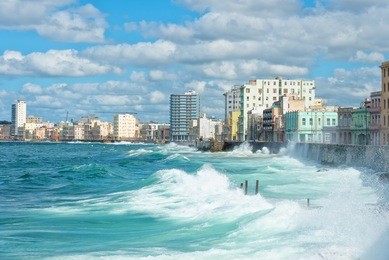 the havana skyline with big sea waves crashing on the malecon seawall