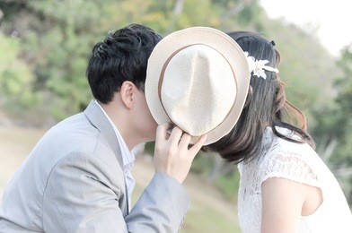 couple in love kissing behind the hat