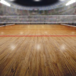 volleyball arena full of fans in the stands with deliberate focus on foreground and shallow depth of field on background net and court. floodlights flare for effect and copy space.