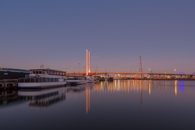 bolte bridge, melbourne with moored boats viewed from docklands waterfront at dawn