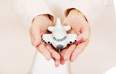 elderly woman holding a toy plane on open plams