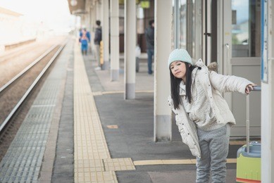 beautiful asian girl waiting for train and happy about a journey