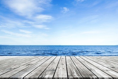 wooden pier with blue sea and sky background
