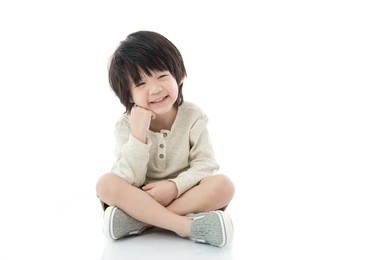 happy asian boy sitting on white background isolated