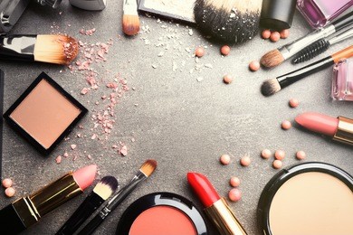 frame of decorative cosmetics and accessories for makeup on grey background