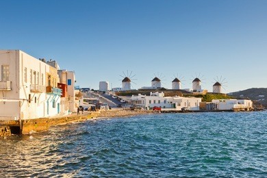 windmills in the town of mykonos as seen from little venice, greece.