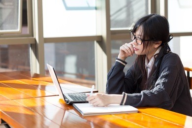 asian girl in uniform studying in library