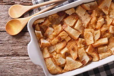 delicious english bread pudding with raisins close up in baking dish on the table. horizontal view from above