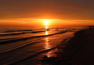 beautiful blazing sunset landscape at black sea and orange sky above it with awesome sun golden reflection on calm waves as a background. amazing summer sunset view on the beach. russian nature, sochi