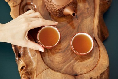 top view tea set a wooden table for tea ceremony background. woman holding a cup of tea
