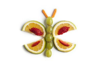food art creative concepts. cute butterfly made of fruits, orange, grapes, strawberry and carrots isolated on white background.