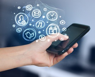 hand holding smartphone with glowing mobile app choices